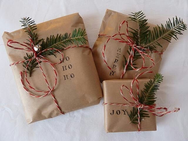 Pacchetti con carta da pacco, corda colorata e rametti di pino